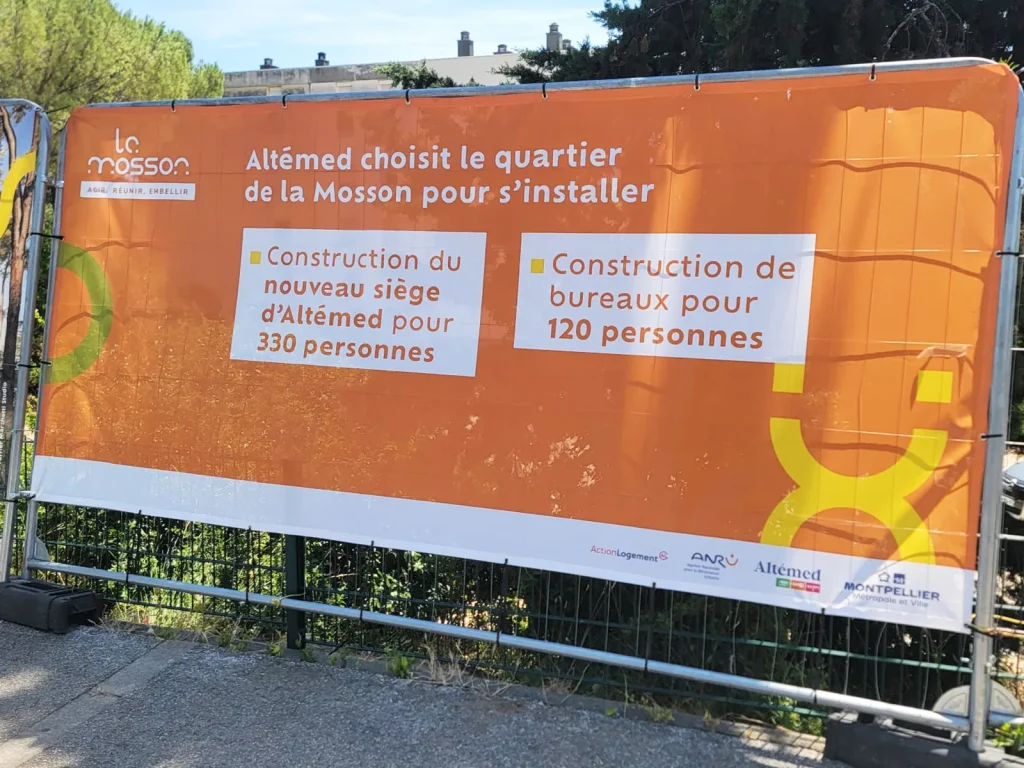 Pose de sept bâches microperforées sur palissade de chantier pour Altemed à Montpellier