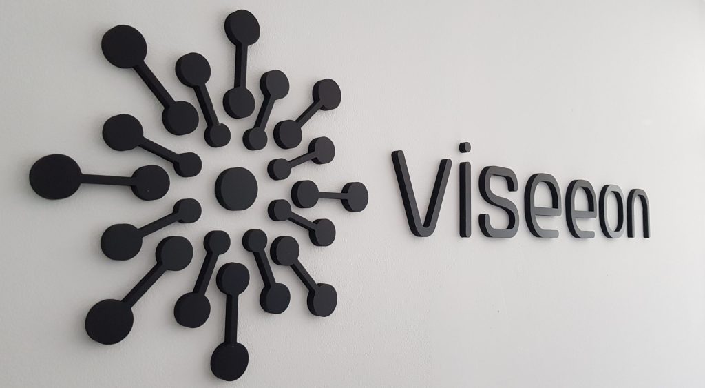 Logo et lettres en relief noires posés sur un mur blanc, agence Viseeon