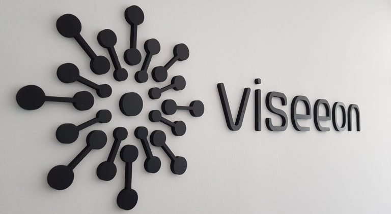Logo et lettres en relief noires posés sur un mur blanc, agence Viseeon