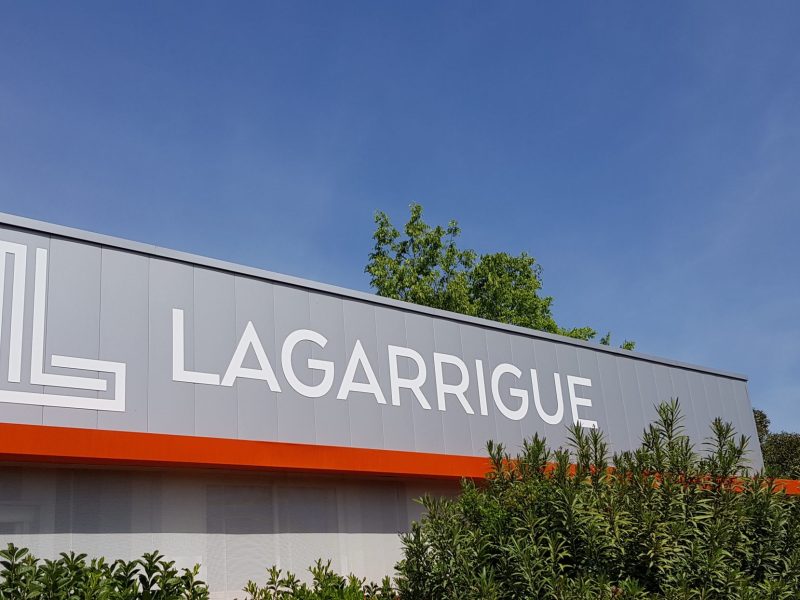 Grandes lettres découpées blanches sur un bardage gris, enseigne Lagarrigue