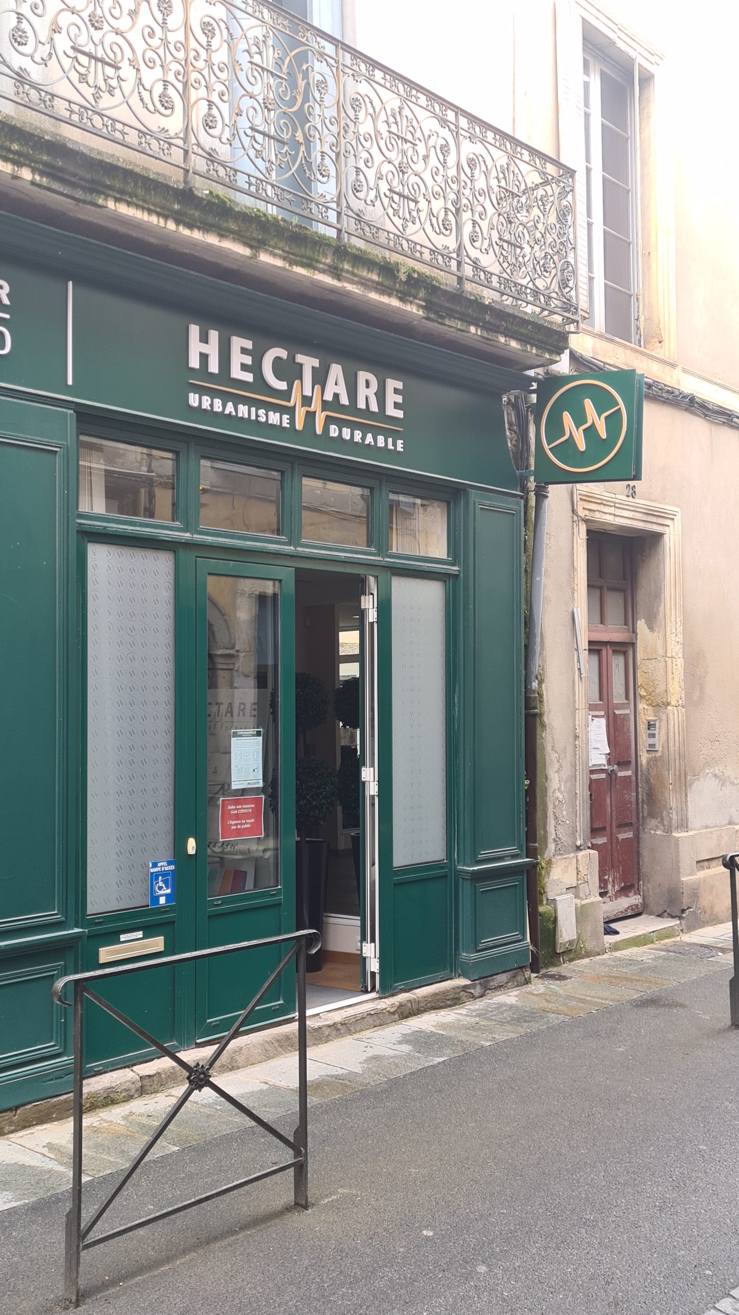 Devanture verte avec bandeau en lettres relief et enseigne drapeau carrée