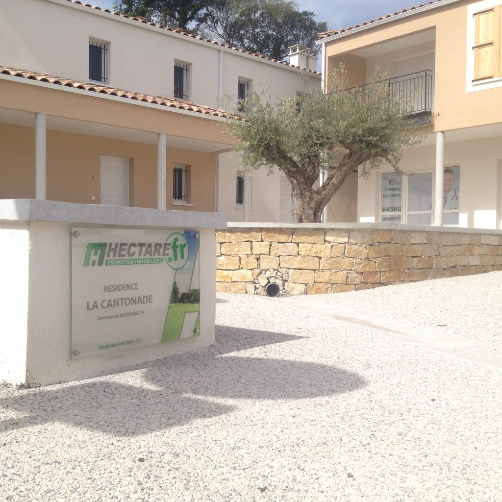 Plaque en plexiglas imprimée fixée sur entretoises à l'entrée d'une résidence