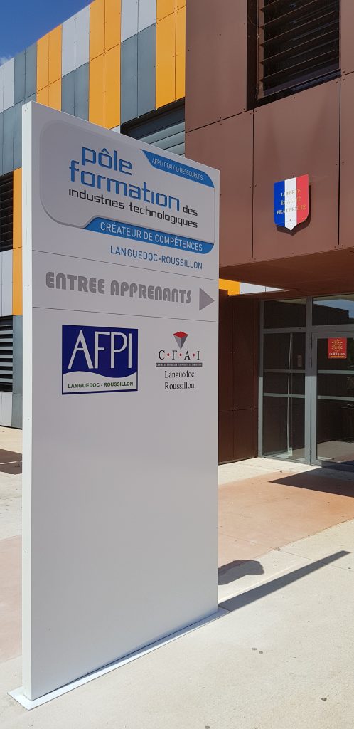 Totem gris d'entrée de site avec fléchage Entrée apprenants, Pôle formation