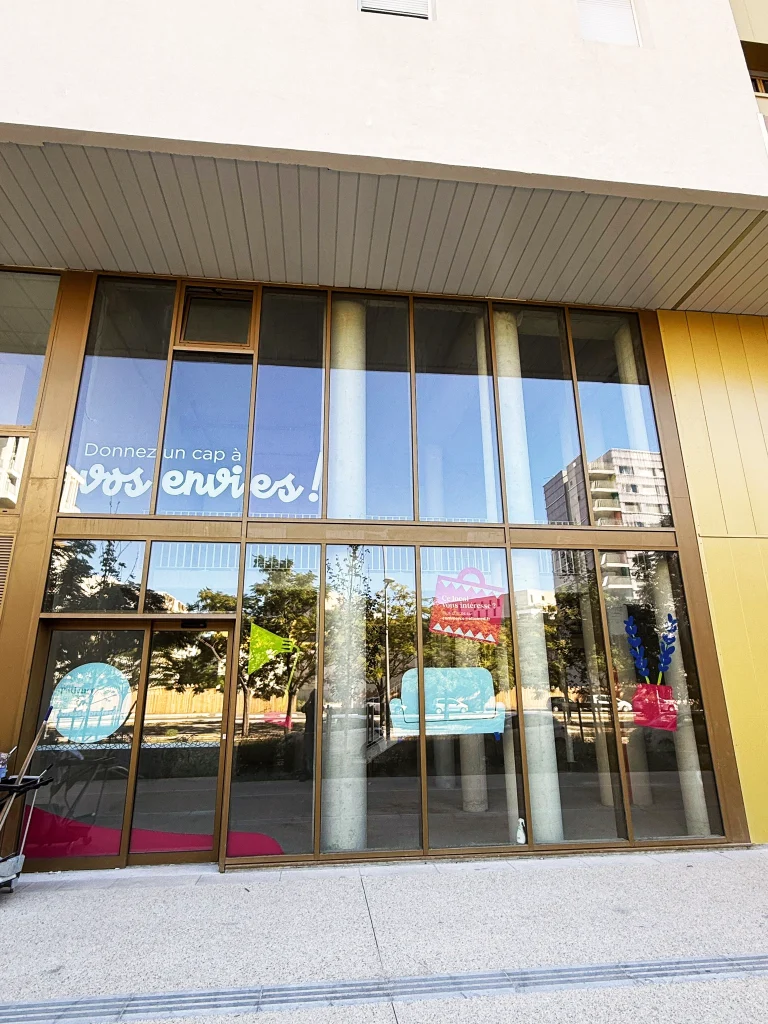 Lettrage adhésif vitrine « Donnez un cap à vos envies ! » et motifs en vinyle découpé sur un local commercial de Port Marianne